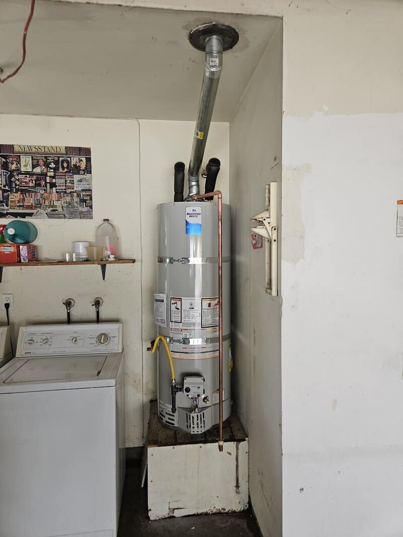 bradford-white-water-heater-fountain-valley-garage A Bradford White tank water heater installed in a Fountain Valley garage with code-compliant venting and connections.