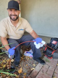 drainage-service-sewer-cleanout-orange-county Oscar from Professional Plumbing running a camera down a drain line at an Orange County job site