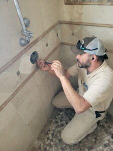 repair-service-shower-cartridge-replacement-orange-county A Professional Plumbing technician replacing a worn shower valve cartridge at a home in Orange County