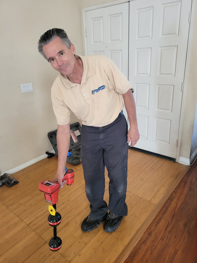slab-leak-detection-equipment-orange-county Professional Plumbing technician holding electronic leak detection equipment used to locate slab leaks under concrete